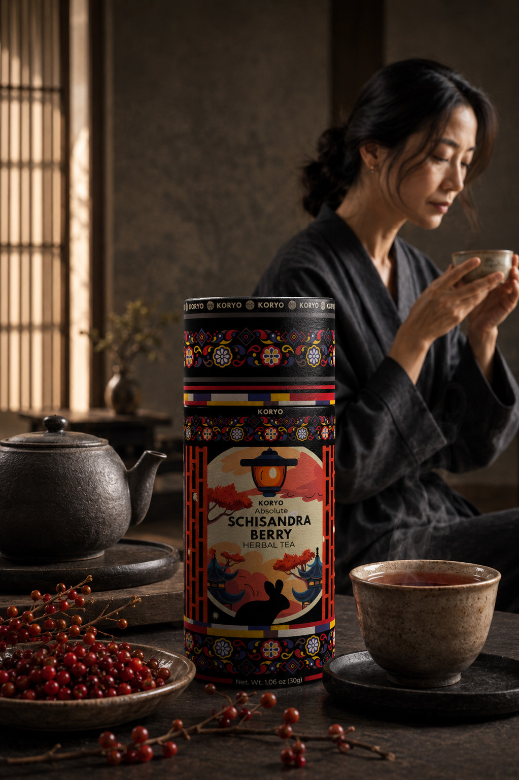 KORYO Schisandra Berry Herbal Tea canister with red berries, steaming tea, ceramic teaware, and a woman enjoying tea in the background.