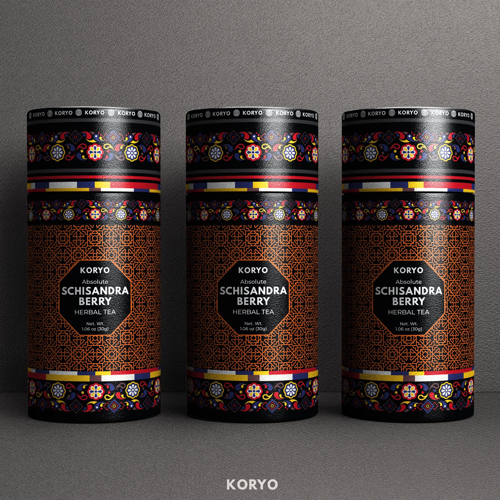 Three black KORYO Schisandra Berry Herbal Tea canisters featuring a copper geometric lattice, colorful Korean-inspired floral borders, and multicolor structural bands.